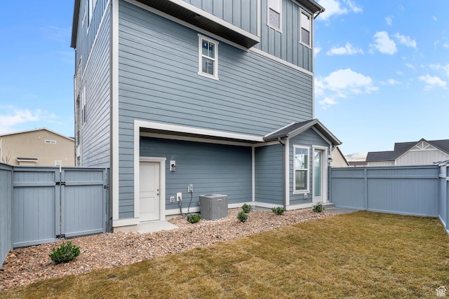 rear view of property with a yard and central AC unit