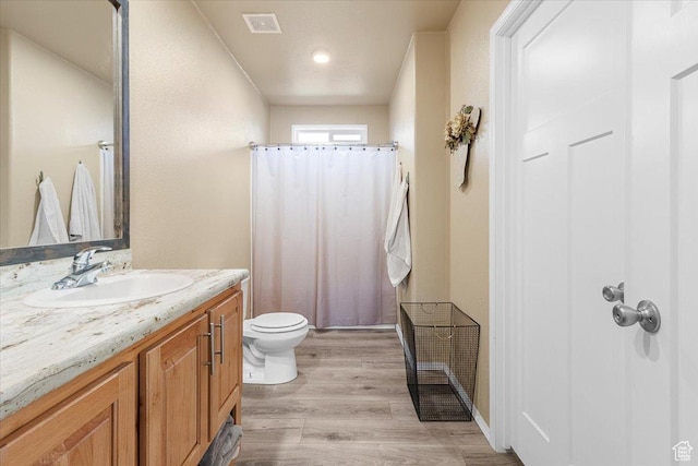 bathroom featuring wood-type flooring, vanity, toilet, and a shower with curtain