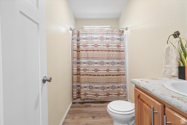 bathroom featuring vanity, hardwood / wood-style flooring, toilet, and walk in shower