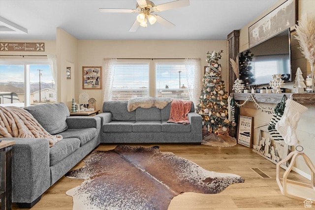 living room with light hardwood / wood-style flooring and ceiling fan