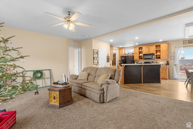 living room featuring ceiling fan and light hardwood / wood-style floors