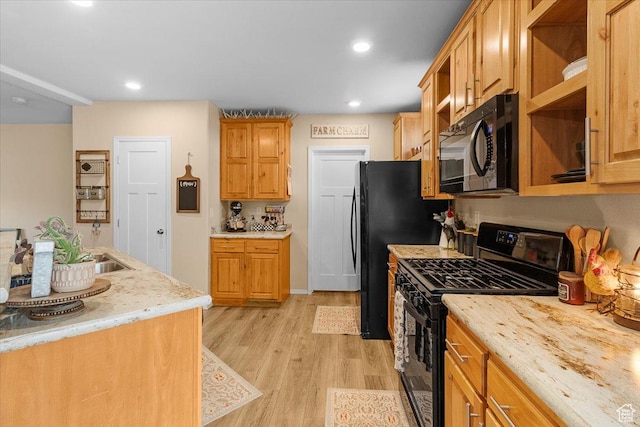 kitchen with wooden counters, light wood-type flooring, and black appliances
