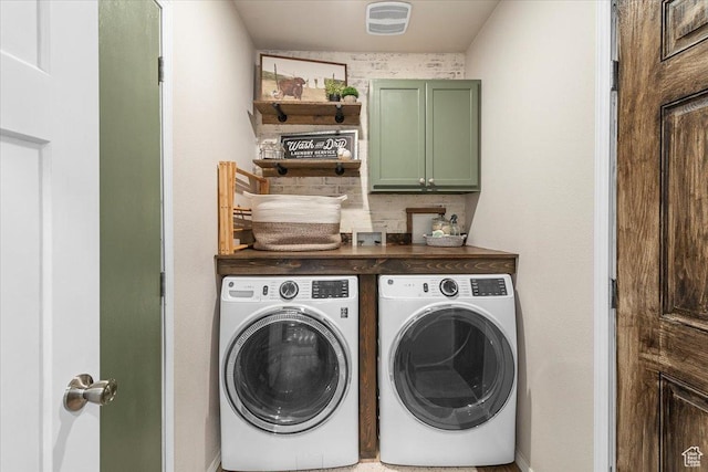 laundry room featuring separate washer and dryer and cabinets
