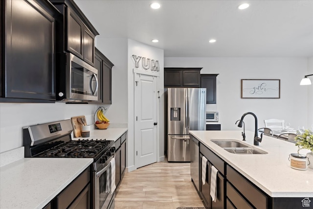 513 S Valkyries Ln, Saratoga Springs, UT 84045 - kitchen with recessed lighting, light wood-style flooring, a center island with sink, stainless steel appliances, and a sink