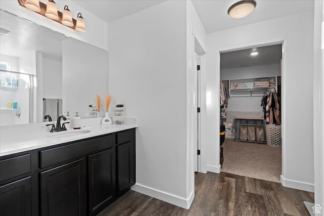 513 S Valkyries Ln, Saratoga Springs, UT 84045 - full bathroom with a walk in closet, vanity, baseboards, and wood finished floors