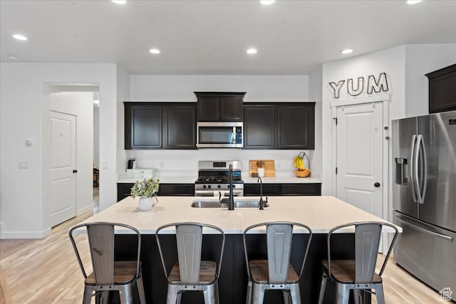 513 S Valkyries Ln, Saratoga Springs, UT 84045 - kitchen with a kitchen bar, recessed lighting, appliances with stainless steel finishes, a sink, and light wood finished floors
