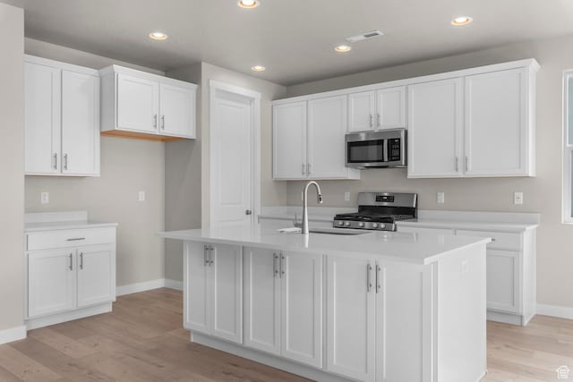 1839 S 2475 W, West Haven, UT 84401 - kitchen featuring white cabinets, sink, a kitchen island with sink, and appliances with stainless steel finishes