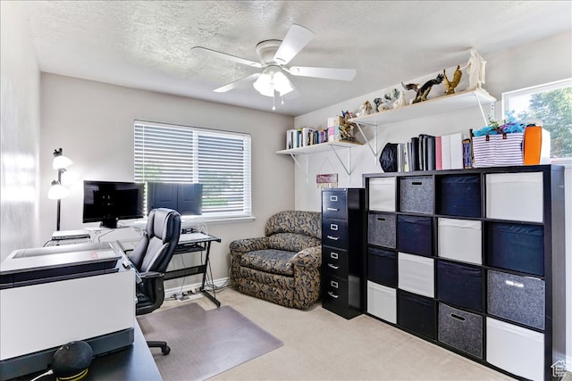 carpeted office featuring a ceiling fan and a textured ceiling