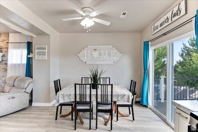 dining room with baseboards, visible vents, a ceiling fan, and light wood-style floors