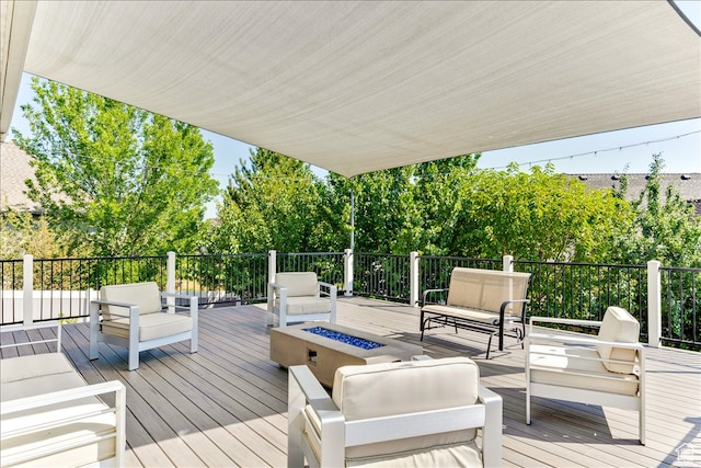 deck with an outdoor living space with a fire pit