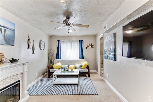 living room with a textured ceiling, visible vents, baseboards, carpet floors, and a ceiling fan