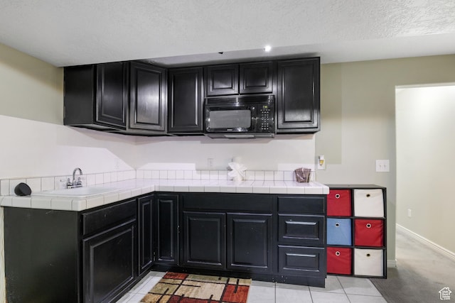 486 N 200 E, Santaquin, UT 84655 - kitchen with black microwave, dark cabinetry, a sink, a textured ceiling, and baseboards