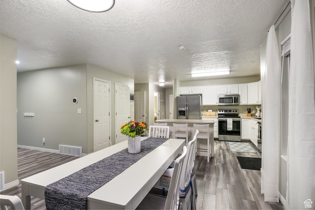 486 N 200 E, Santaquin, UT 84655 - dining room featuring wood finished floors, a textured ceiling, and baseboards