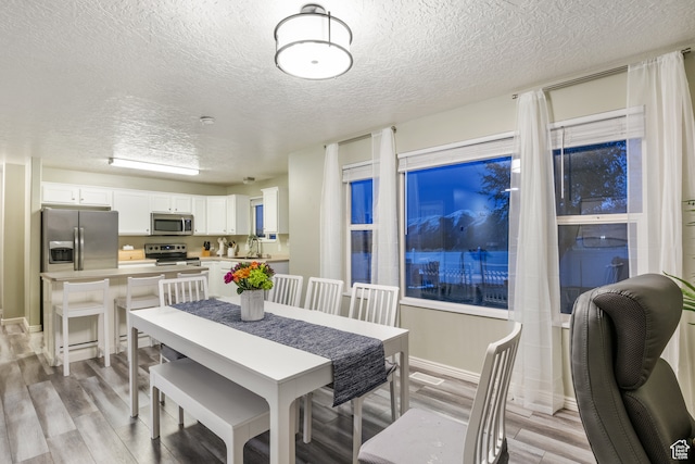 486 N 200 E, Santaquin, UT 84655 - dining area featuring a textured ceiling, light wood-style floors, and baseboards