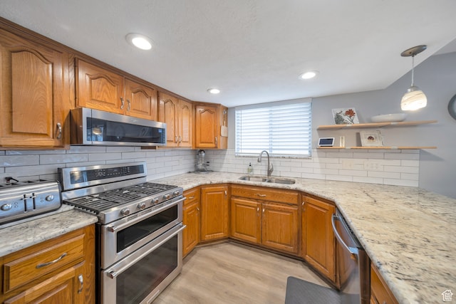 kitchen featuring light stone countertops, sink, stainless steel appliances, and light hardwood / wood-style floors