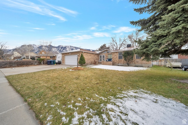 single story home featuring a mountain view, a garage, and a front yard