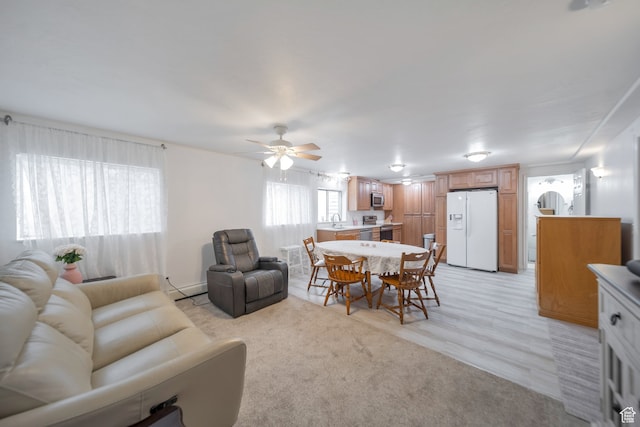 carpeted living room featuring ceiling fan and sink