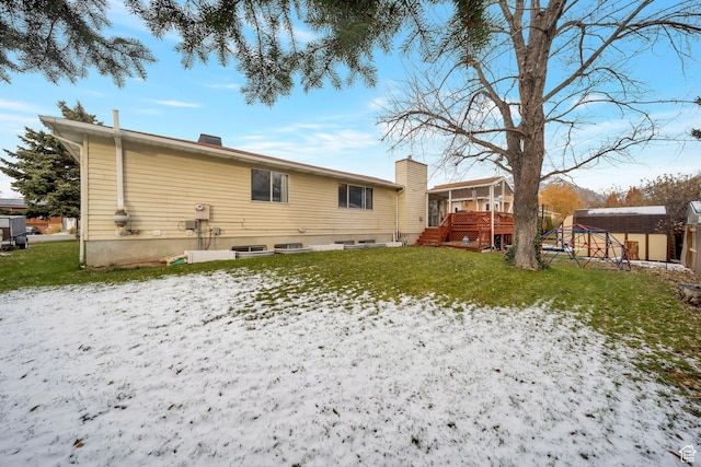 rear view of house with a storage shed, a deck, and a yard
