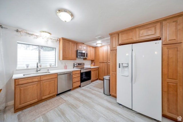 kitchen with sink, light hardwood / wood-style flooring, and appliances with stainless steel finishes