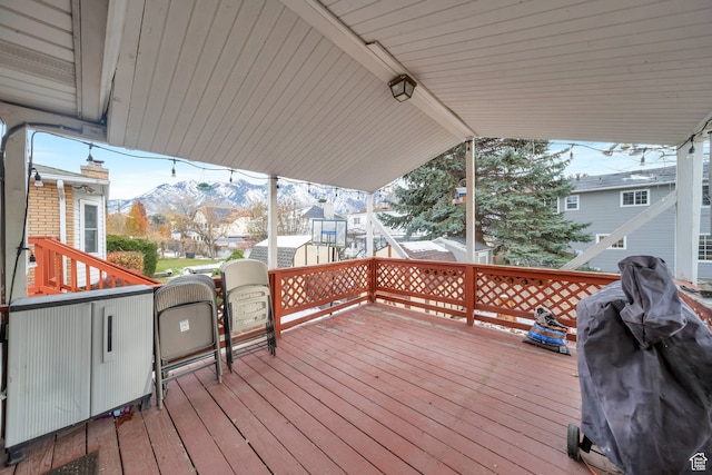 wooden deck with a mountain view and grilling area
