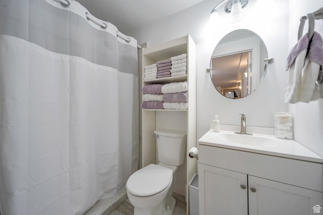bathroom with curtained shower, vanity, and toilet