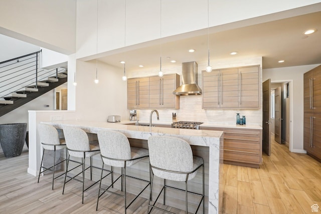 6412 Golden Bear Loop W, Park City, UT 84098 - kitchen with wall chimney exhaust hood, a kitchen bar, light wood-style flooring, and recessed lighting