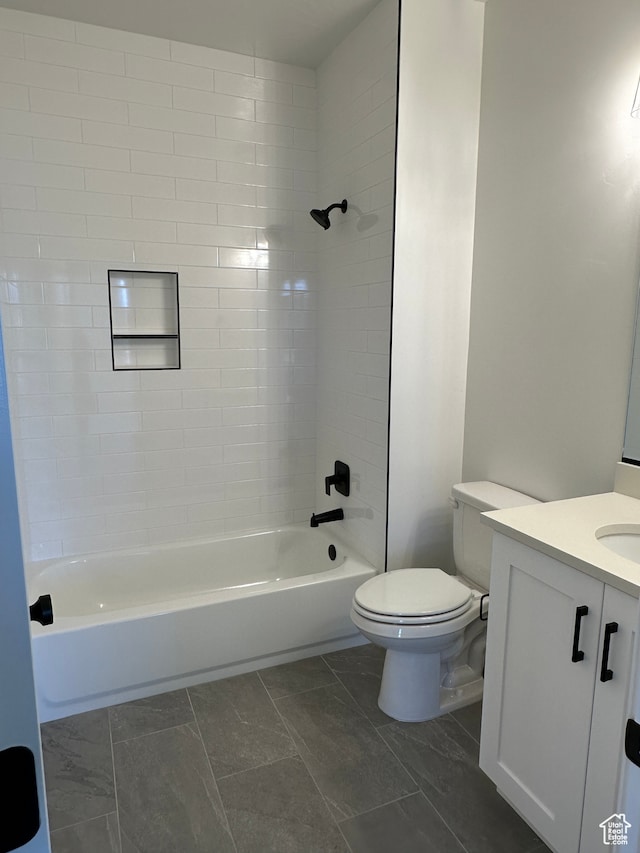 full bathroom with vanity, tiled shower / bath combo, and toilet