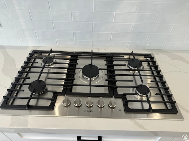 interior details featuring light stone countertops and stainless steel gas cooktop