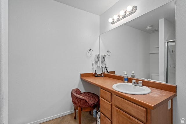 bathroom with tile patterned floors, vanity, toilet, and walk in shower
