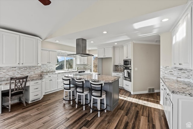 kitchen featuring decorative backsplash, island range hood, and white cabinetry