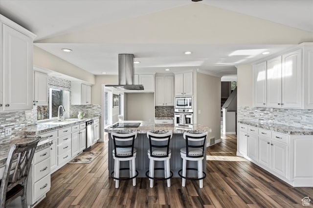 kitchen with white cabinetry, lofted ceiling, decorative backsplash, island range hood, and appliances with stainless steel finishes
