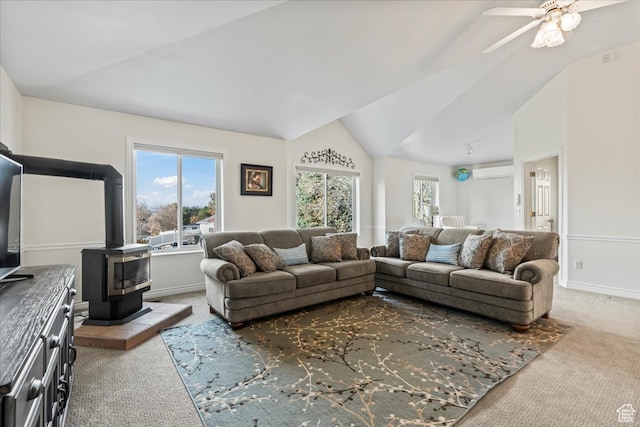 living room with carpet, vaulted ceiling, a wood stove, and ceiling fan