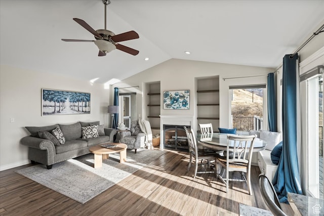 living room with hardwood / wood-style flooring, ceiling fan, and lofted ceiling