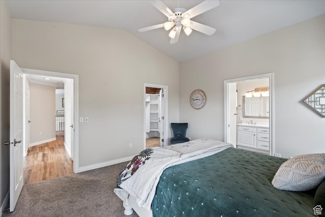 bedroom with a walk in closet, ensuite bathroom, ceiling fan, a closet, and lofted ceiling