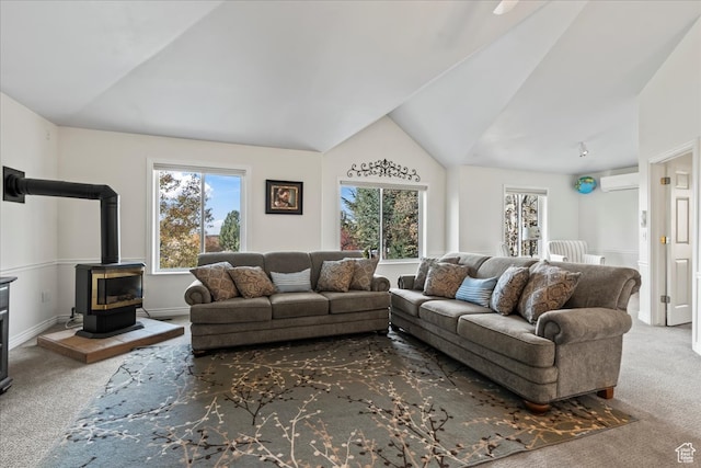 living room featuring a wall unit AC, a wood stove, carpet, and lofted ceiling