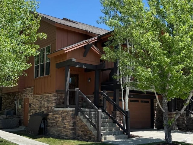 980 W White Cloud Trl, Hideout, UT 84036 - view of front facade with board and batten siding, an attached garage, driveway, stone siding, and a shingled roof
