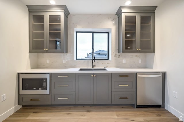 176 S 1150 E, Pleasant Grove, UT 84062 - bar area with stainless steel appliances, a sink, tasteful backsplash, baseboards, and light wood-type flooring