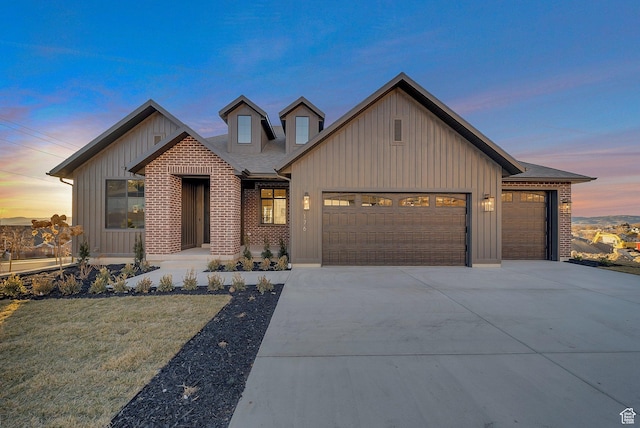 modern farmhouse style home featuring a garage, a shingled roof, concrete driveway, board and batten siding, and brick siding
