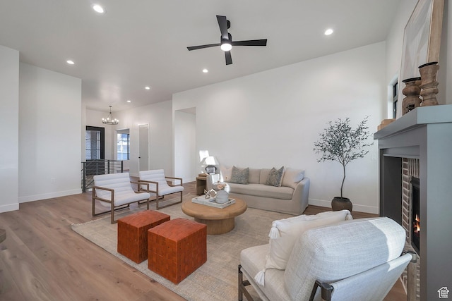 176 S 1150 E, Pleasant Grove, UT 84062 - living room featuring a warm lit fireplace, light wood-type flooring, recessed lighting, baseboards, and a ceiling fan