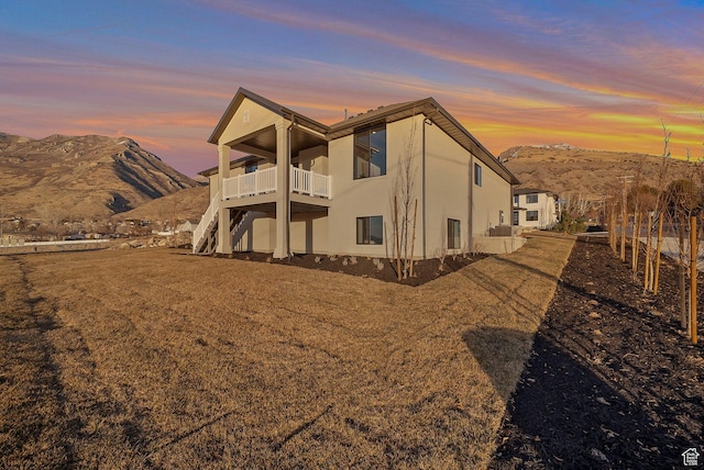 176 S 1150 E, Pleasant Grove, UT 84062 - back of property at dusk featuring a mountain view, stucco siding, a balcony, and stairway