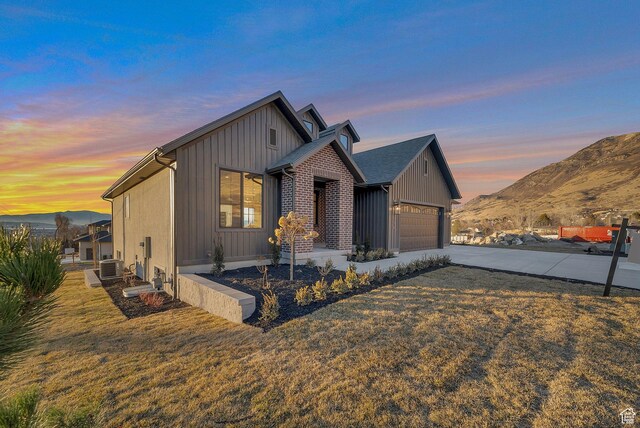 176 S 1150 E, Pleasant Grove, UT 84062 - view of front of property featuring concrete driveway, central AC, a mountain view, an attached garage, and a front lawn