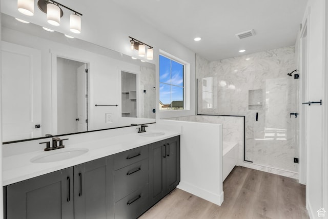 652 W Emerald Point Dr Unit 131, St George, UT 84790 - bathroom featuring a marble finish shower, double vanity, wood finished floors, a bath, and recessed lighting