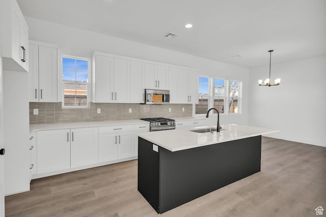 652 W Emerald Point Dr Unit 131, St George, UT 84790 - kitchen with a sink, appliances with stainless steel finishes, decorative backsplash, light countertops, and white cabinetry