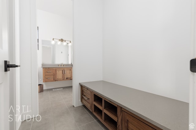 mudroom featuring light tile patterned floors and a sink