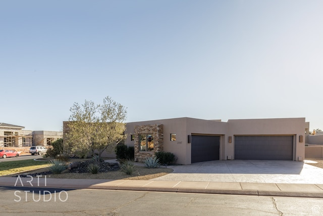 adobe home with a garage, driveway, and stucco siding