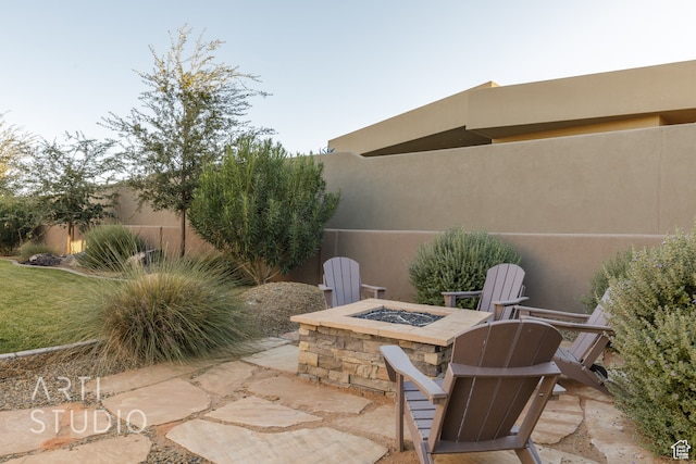 view of patio / terrace with an outdoor fire pit and fence
