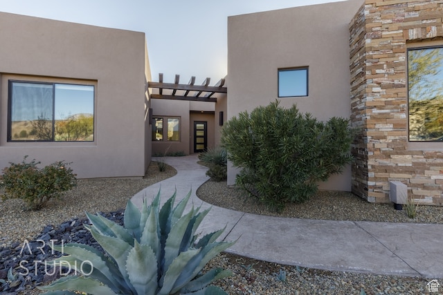 view of front of property featuring a pergola and stucco siding