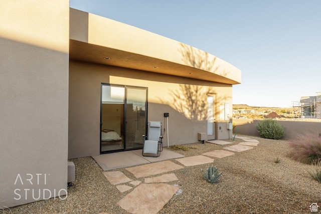 rear view of property featuring a patio and stucco siding