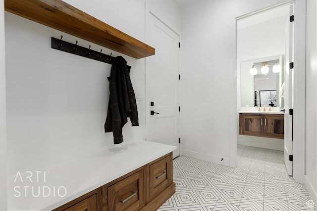 mudroom with a sink and baseboards