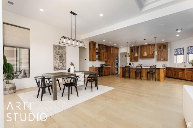 dining space with light wood finished floors, visible vents, and recessed lighting